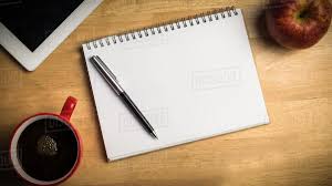 Overhead of notepad and pen on a cluttered desk - Stock Photo - Dissolve